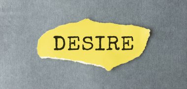 DESIRE metni. Gri arkaplanda yırtık sarı kağıt arkasında