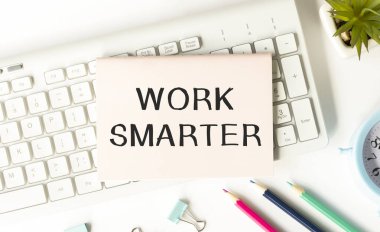 Klavyede duran bir dizüstü bilgisayara yazılmış WorK SMARTER metni.