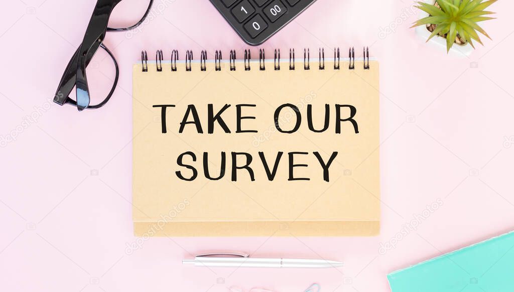 Take Our Survey. written on notepad with pencil on pink background. Business concept.