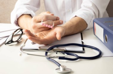 Bilgisayarda bir çanta dolusu hapı olan bir doktor.