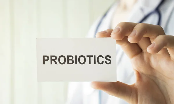 Doktor elinde metin probiyotiği tıbbi konsepti olan bir kart tutuyor.