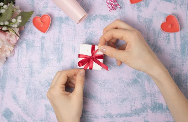 Mani Femminili Tirano Nastro Rosso Una Scatola Regalo Uno Sfondo — Foto Stock