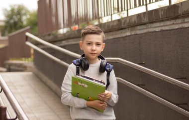Küçük çocuk okula geri dönüyor. İlk okul gününde sırt çantası ve kitapları olan bir çocuk. Arkadan bak. Okul konsepti. Okula geri dön..