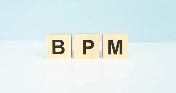 Acronym BPM - Business process management. Wooden small cubes with letters isolated on black background with copy space available. Business Concept image.