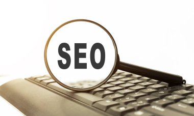 Tahta masadaki metin SEO ile büyüteç.