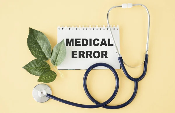 text MEDICAL ERROR write on a medicine card. Medical concept with a stethoscope on a yellow background