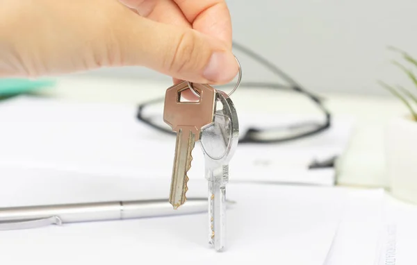 Real Estate Agent Gives The Keys To The House Buyer And Signs The Contract In The Office.