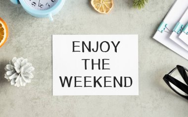 Text Enjoy the Weekend written on the sticky note with glasses.