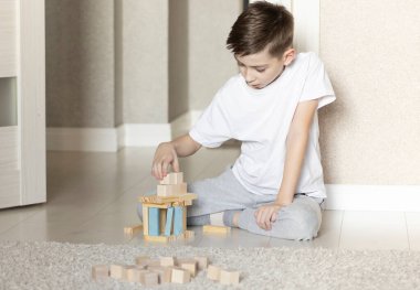 Çocuk tahta bloklarla oynuyor, boş zamanların tadını çıkarıyor.