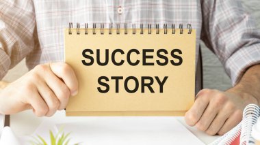 Başarı öyküleri gösterilen metin işareti el yazısı. İş kavramı başarılı ilham başarı eğitim yapışkan not kağıdı tutan el parmak ile yazılmıştır büyüme için.