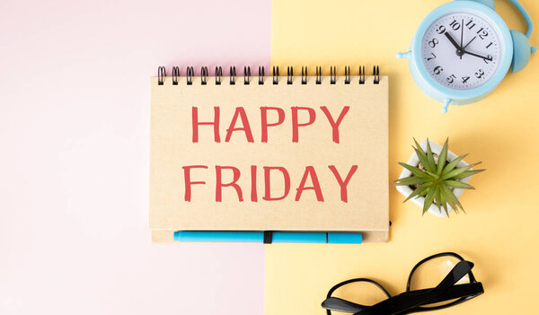 On a notepad the inscription ,Happy friday, on the office desk.