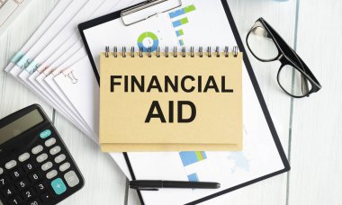 Kalem ve hesap makineli bir deftere yazılmış mali yardım metni.