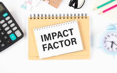 Üzerinde IMPACT FACTOR yazan bir kart tutan bir iş adamı. Klavye, diyagram ve beyaz arkaplan