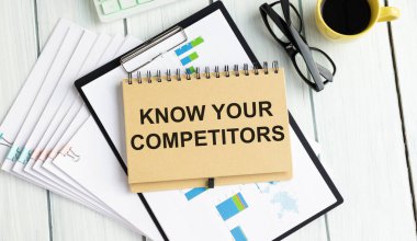 On a sheet of diary the inscription KNOW YOUR COMPETITOR, next to a pencil pointing to it, and glasses.