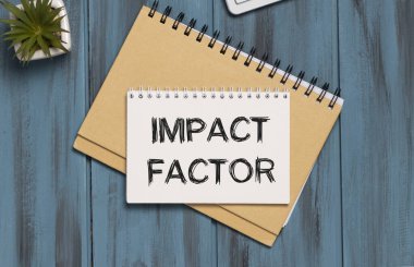 Üzerinde IMPACT FACTOR yazan bir kart tutan bir iş adamı. Klavye, diyagram ve beyaz arkaplan