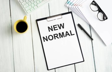 Klavye, kalem, büyüteç ve New Normal ile yazılmış bir kitap. Bu salgın yüzünden dünya bu yeni normalle yaşamaya başlıyor..