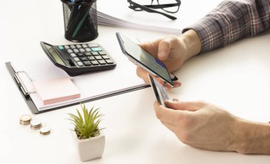 Evde online alışveriş yapmak için akıllı telefon ve dizüstü bilgisayar kullanan erkek elleri, Ödeme Detaylı sayfa görüntüleme ve kredi kartı ile cep telefonu tutan eller, online alışveriş kavramları