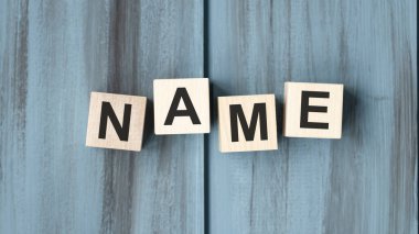 Tahta blokta yazan kelime. Ahşap masadaki isim metni desing, konsept için.