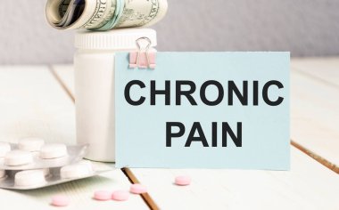 Beyaz bir kağıda yazılmış kronik ağrı teşhisi. Tedavi ve hastalıkların önlenmesi. Şırınga ve ilaçlı aşı. Tıbbi ve Sağlık Hizmetleri konsepti. Seçici odak