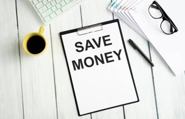 Belgeler ve diğer nesneler ile ofis masası ve metin Para Kaydet.