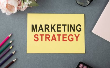 Pazarlama stratejisi planlıyorum. Üst görüntüde, ahşap masada otururken renkli çizimlerle el ele tutuşan bir adam görülüyor.