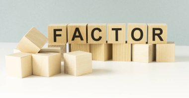 Işık arkaplanındaki bloklar üzerine FACTOR kelimesi