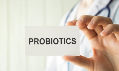 Doktor elinde metin probiyotiği tıbbi konsepti olan bir kart tutuyor.