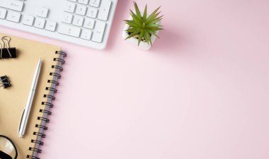 Ofis yazma malzemeleri, teknik cihazlar, akıllı telefon ve pembe arka planda bir demet pembe çiçek içeren bayrak veya dükkan başlığı metin ve markalaşma üst görünümün için