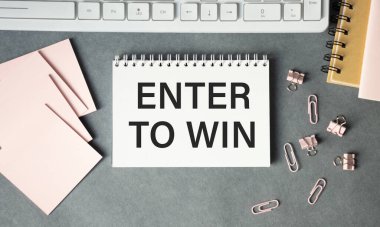 Hesap makinesi ve ofis malzemelerinin yanında, beyaz bir arkaplanda kazanmak için metin girdisi olan not defteri. İş konsepti.