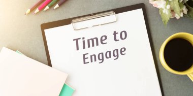 Metin, bağlanma zamanı kelimesi siyah bir masada bir kalem ve bir fincan kahveyle duran bir deftere yazılmıştır. İş konsepti