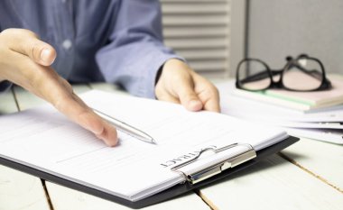 Ofiste birlikte çalışan meslektaşların yakın çekimleri kağıtları tartışıyor.