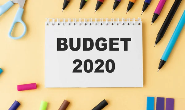 Budget 2020 text concept. Office workplace table with calculator, glasses, textbook and keyboard, budget 2020.