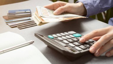 Muhasebe masrafları yapan ve kredi kartı borçlarını ödeyen bir kadın..