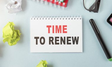 Aydınlık bir arkaplan, gözlük ve kırtasiye yakınında yenilenecek metin zamanını not et.