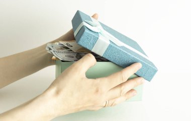 Masanın üzerinde büyük bir altın para olan hediye kutusunu aç. Para Hediyesi Konsepti.