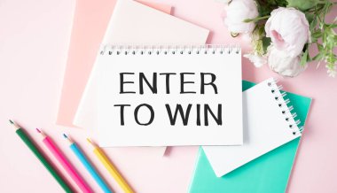 İş konsepti. Not defteri ve kalemlerle masada kazanmak için ENTER to WIN yazılı kart