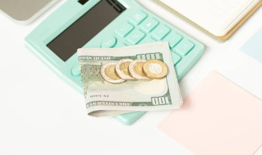 Bir hesap makinesinde dolar ve madeni paralar, iş konsepti.