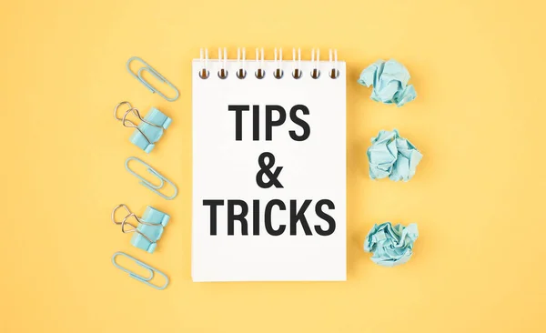 Tips And Tricks concept on desktop workspace with office supplies.