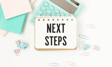 Tablet bilgisayar ve klavye ile ahşap masa üzerinde NEXT STEPS metin