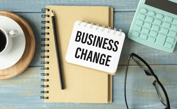 Business Change text on Notebook on wooden table.