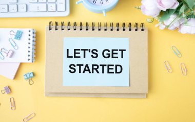 Beyaz yüzük klasörü defterinden başlayalım. Sarı masa üzerinde kurşun kalem, iş konsepti..