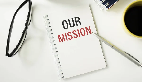 Our Mission text written on a businessman diary. Conceptual of business, education, finance, news.