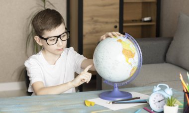 Gülümseyen küçük çocuğun portresi masasında oturuyor.