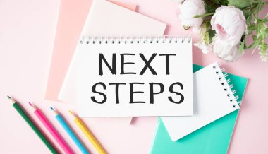 Tahta masadaki tabletli NEXT STEPS metni