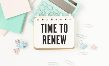 Dizüstü bilgisayar ve ahşap arka planda yeniden yenilemek için metin zamanı içeren not defteri