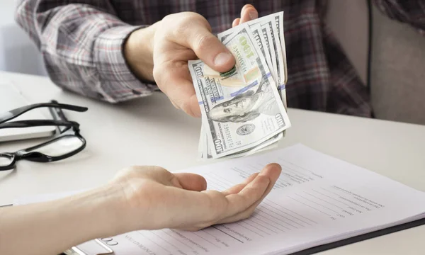 Genç adam elinde bir dolar saydı, mali hesap yönetimi ve ödeme veya tasarruf kavramı.