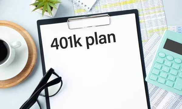 Phrase 401K PLAN written on paper clipboard with pen,calculator,eye glasses and charts report. Finance and business concept.