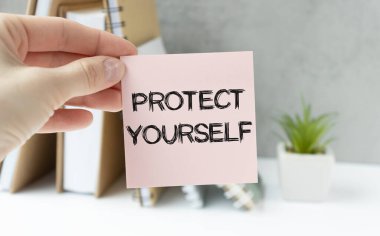 Üzerinde PROTECT SENSEL mesajı olan bir kartvizit tutan işadamına yakın plan, yumuşak odaklı iş konsepti resmi