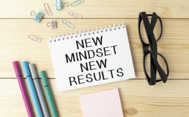 Yeni zihniyet, not defterine yazılmış yeni sonuç mektupları, çalışma masası üst görünümü. Motivasyonel kişisel gelişim iş tipografisi kavramından alıntılar yapıyor