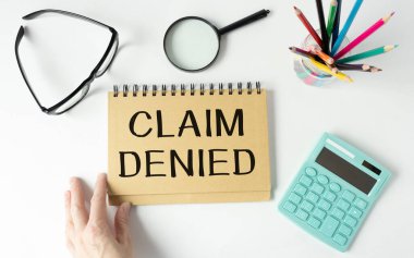 CLAIM DENIED. Finansal belgelerde kalemle not defterine yazılan metin.